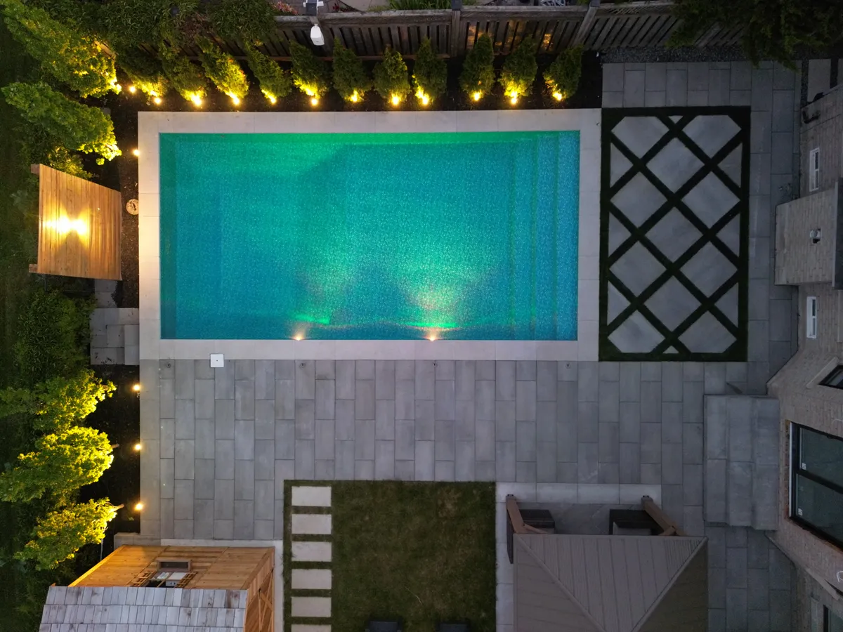 Aerial view of a rectangular fibreglass pool in a landscaped Ontario backyard at dusk