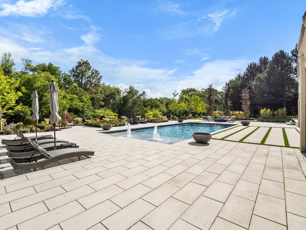 Natural stone pool deck surrounding an Ontario backyard pool