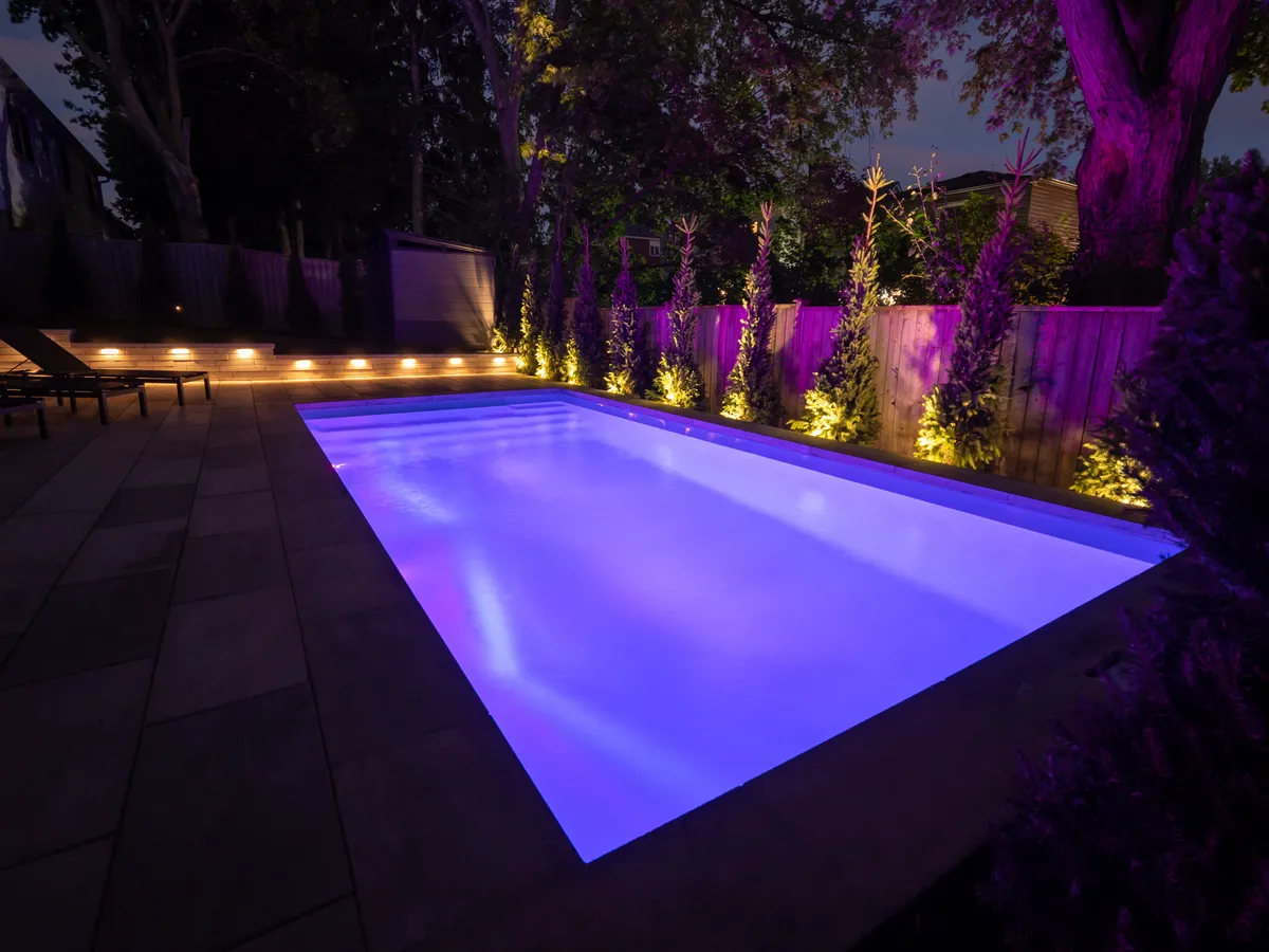 Pool and landscape lighting illuminating an Ontario backyard at night