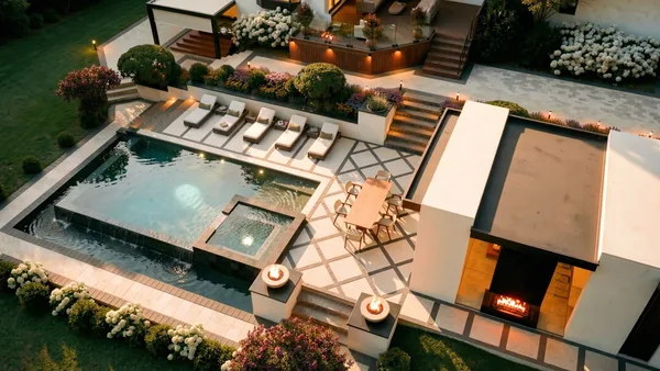 Brule landscape design render &mdash; Top-down aerial at night — cabana fireplace roaring, fire bowls and landscape lighting through the terraces