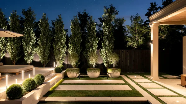 Sculptural planters and lit lawn terraces at night at Richard Serra Ct