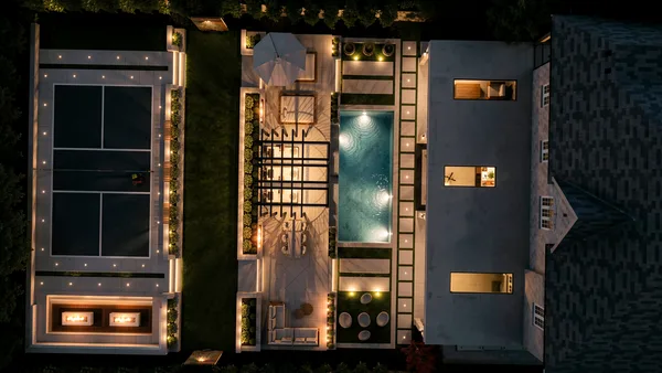 Aerial night view of the Richard Serra Ct design showing the private tennis court, pool and lit outdoor rooms
