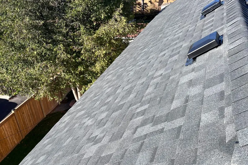 Freshly installed grey architectural shingle roof with ridge vents