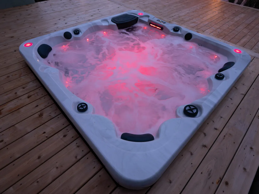 Compact hot tub with hydrotherapy jets and LED lighting installed on a wooden deck