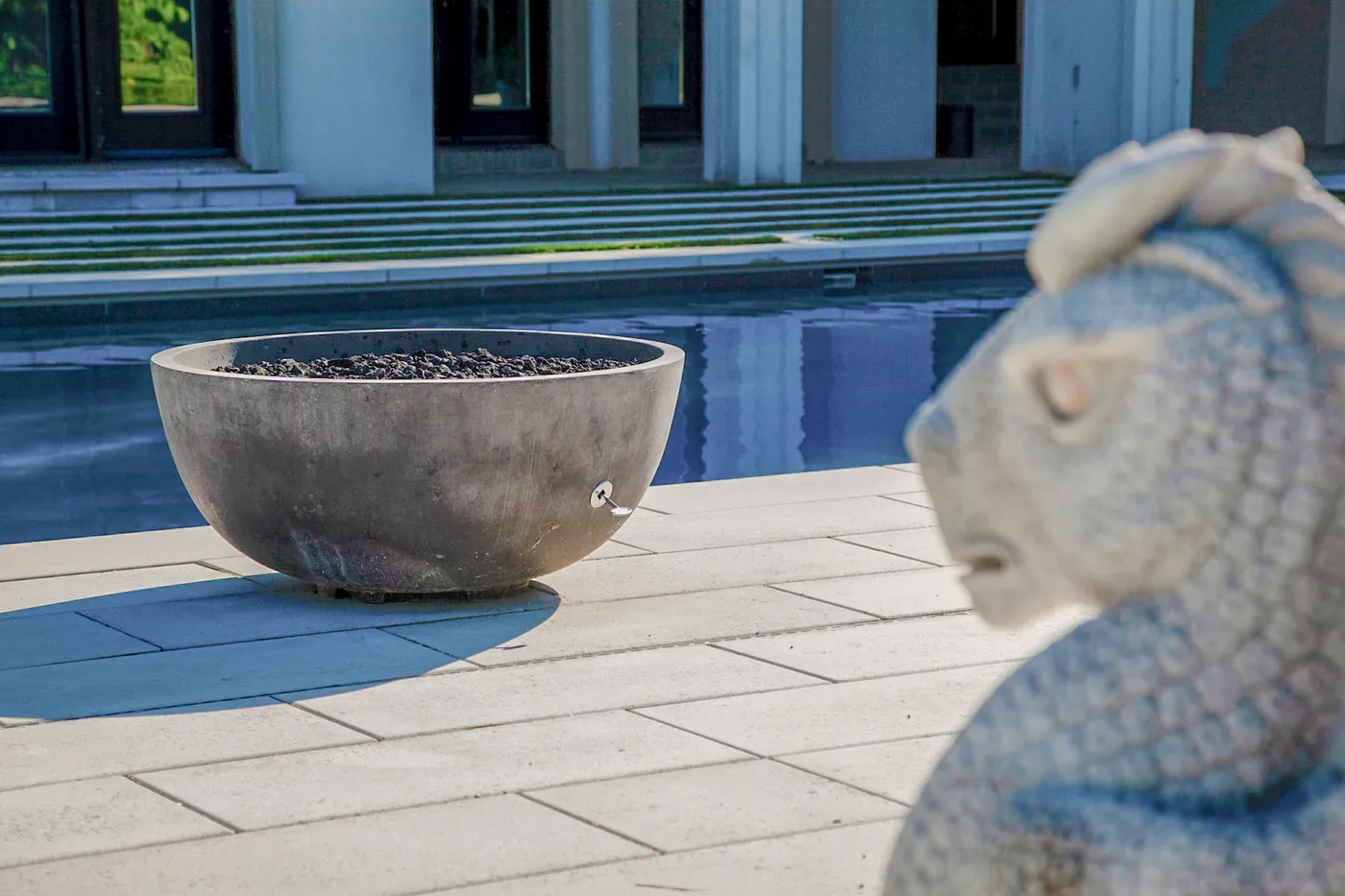 modern concrete bowl planter beside a contemporary pool