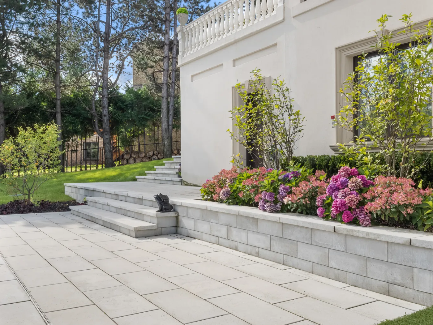 stone planter beds with hydrangeas along an estate home entrance