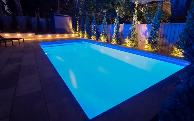 Fiberglass pool lit up at night