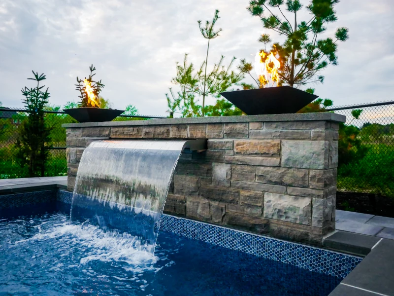 backyard pool with stone floor and stone steps