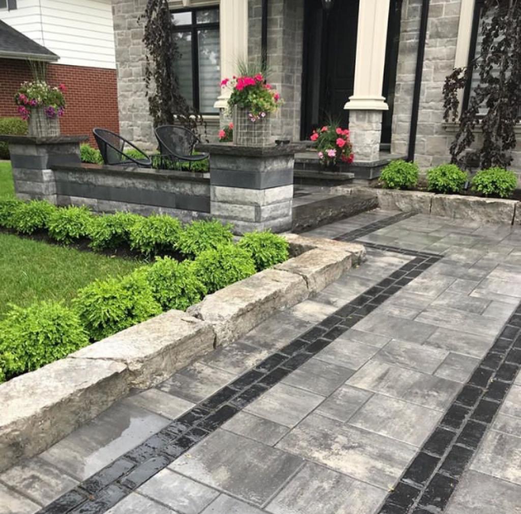 well strimmed small shrubs and flower with cleans cobblestone entrance